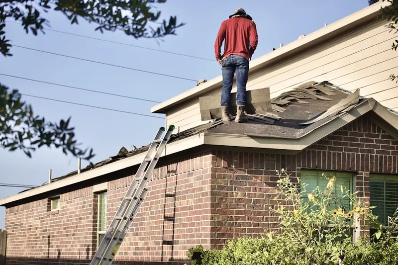 Professional roofer working on a residential roof in Le Sueur